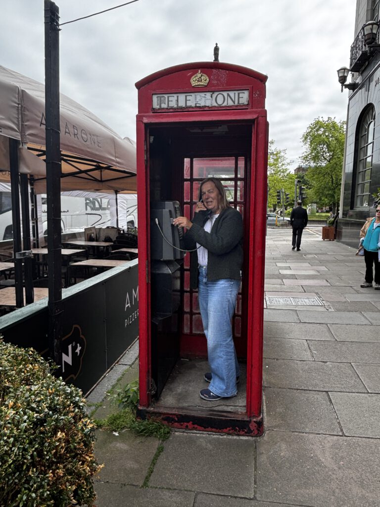 Eine Frau in einer typischen roten Telefonzelle.