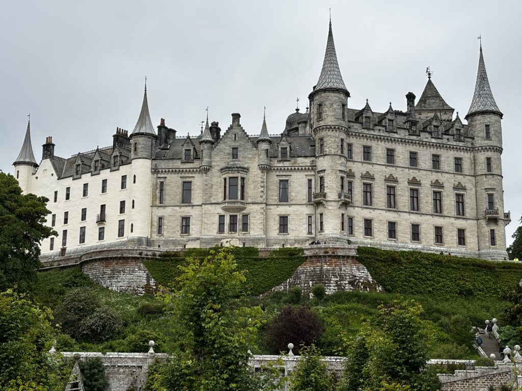 Ein weißes Schloss auf einem Hügel.